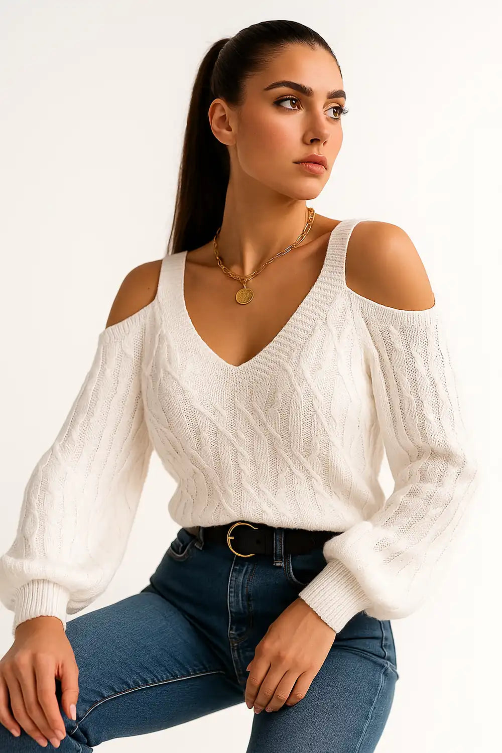 Woman wearing a white cold shoulder knit sweater with balloon sleeves, chic winter outfit